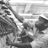 18.6.1987 Joao Nanelo aus Mocambique, der hier im Maschinensaal der Baumwollspinnerei Mittweida im Bezirk Karl-Marx-Stadt eine Spinndüse repariert, ist bereits ein geübter Mechaniker. Gemeinsam mit 100 seiner Landsleute erhielt er hier eine Ausbildung.